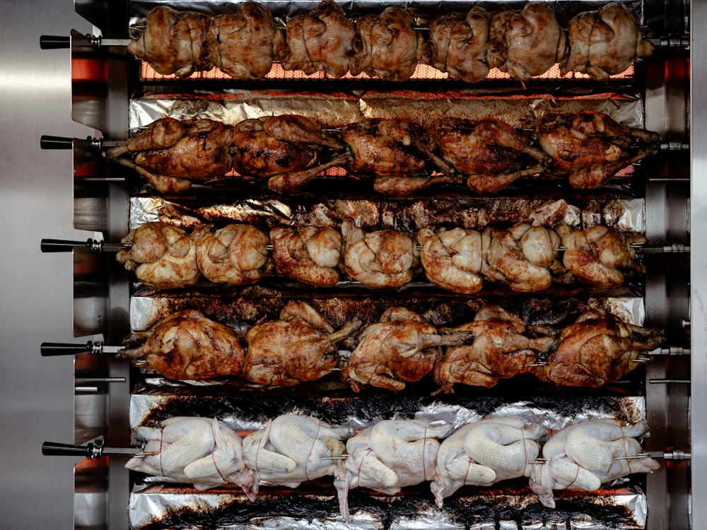Pollos asándose en el asador — foto referencial
